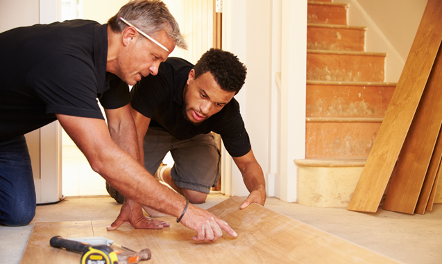 Two workers installing tile