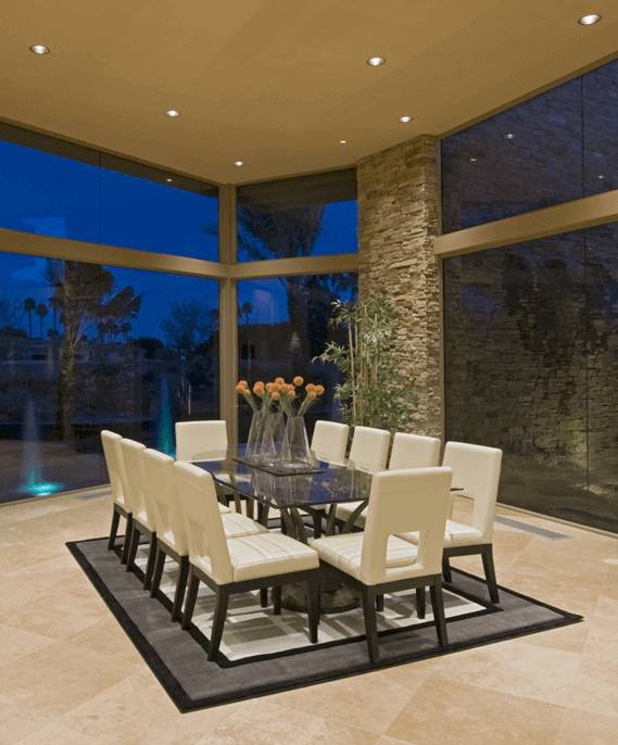 Elegant dining room with patio window and natural stone walls and flooring