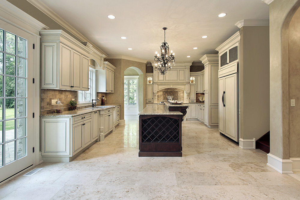 a large kitchen with a chandelier hanging from the ceiling, with granite flooring