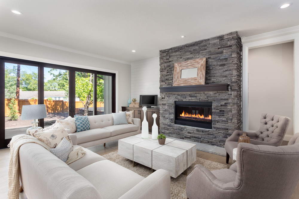 a living room filled with furniture and a fire place, with limestone