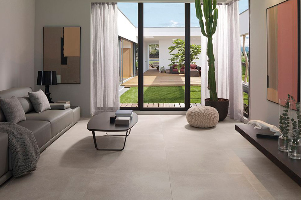 a living room with limestone flooring, filled with furniture and a large window