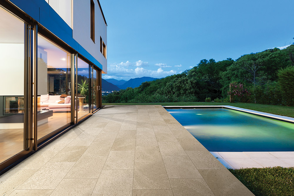 a house with a pool in the middle of it, travertine flooring on the side